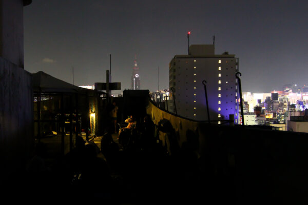 Modern urban skyline at night with iconic New Sky Building in Shinjuku.