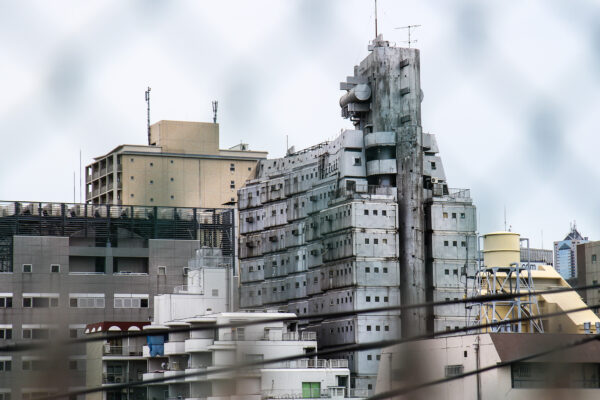 Sleek high-rise: Shinjukus Modern Metabolism Tower in bustling urban landscape.