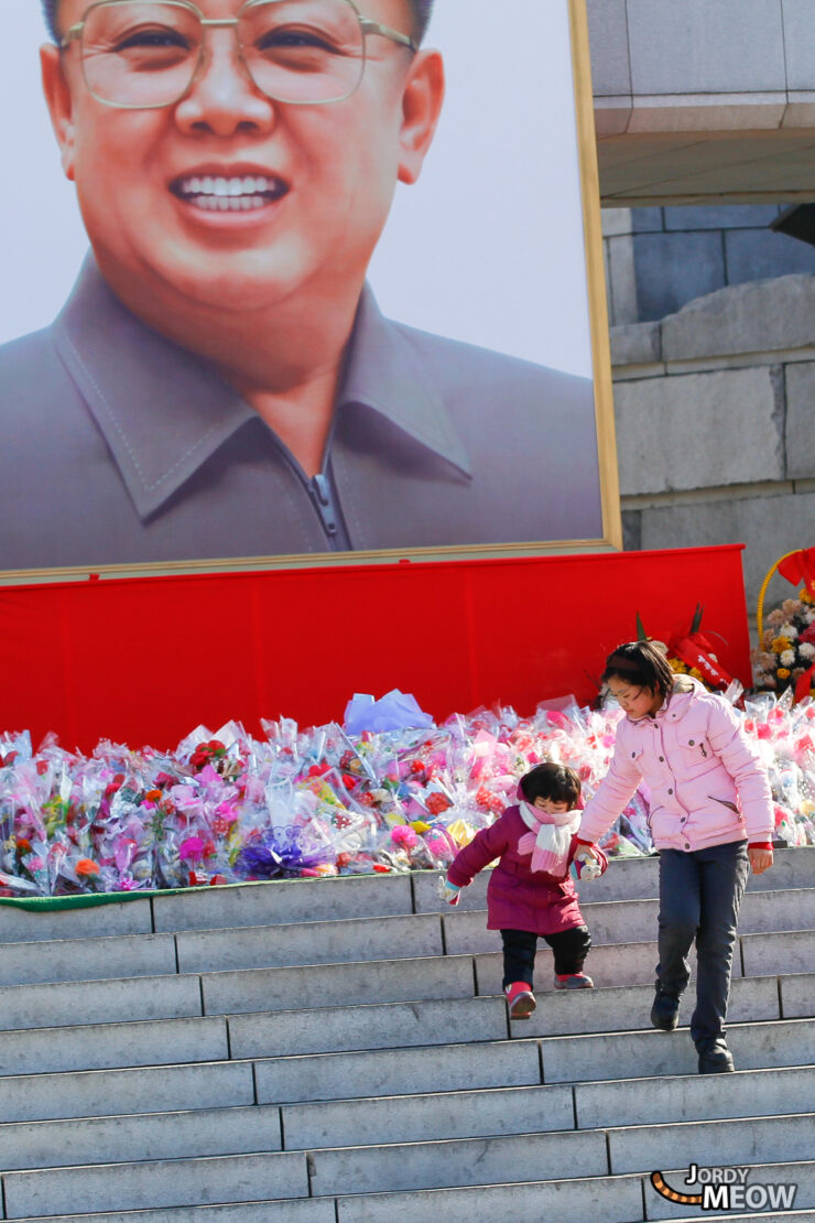 Children enjoying Workers Party monument in North Korea public square.