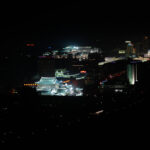 Nighttime skyline of vibrant Pyongyang, North Korea with illuminated buildings and central government structure.