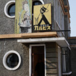 Unique North Korean building with poster and symbolic silhouette reflecting cultural and political landscape.