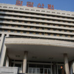 Discovering iconic Pyongyang building with Korean script sign, showcasing cultural significance.