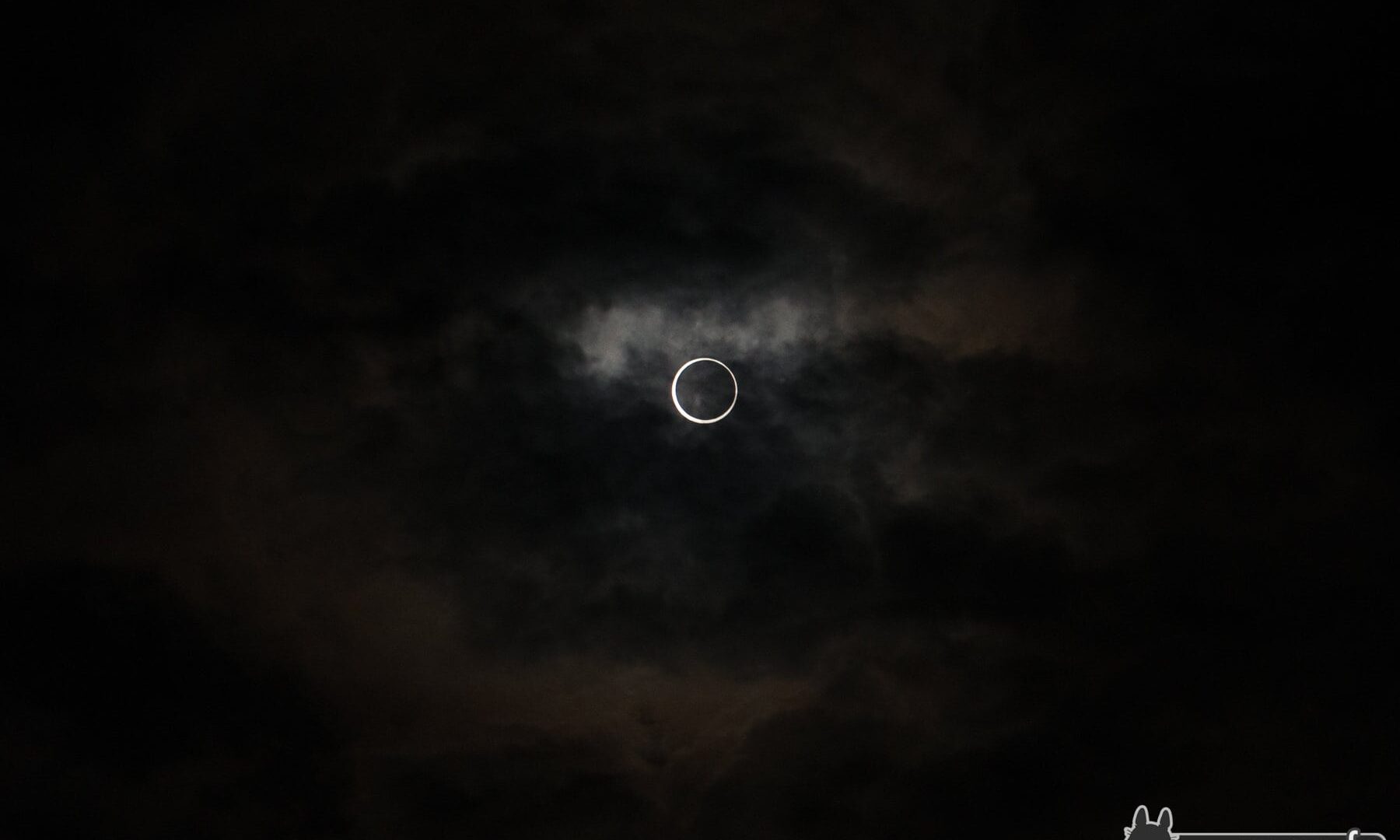 Solar eclipse with suns corona against dark, cloudy sky in Japan 2012.