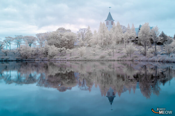 Snowy Japanese theme park ruin in serene winter scene with abandoned castle reflection.