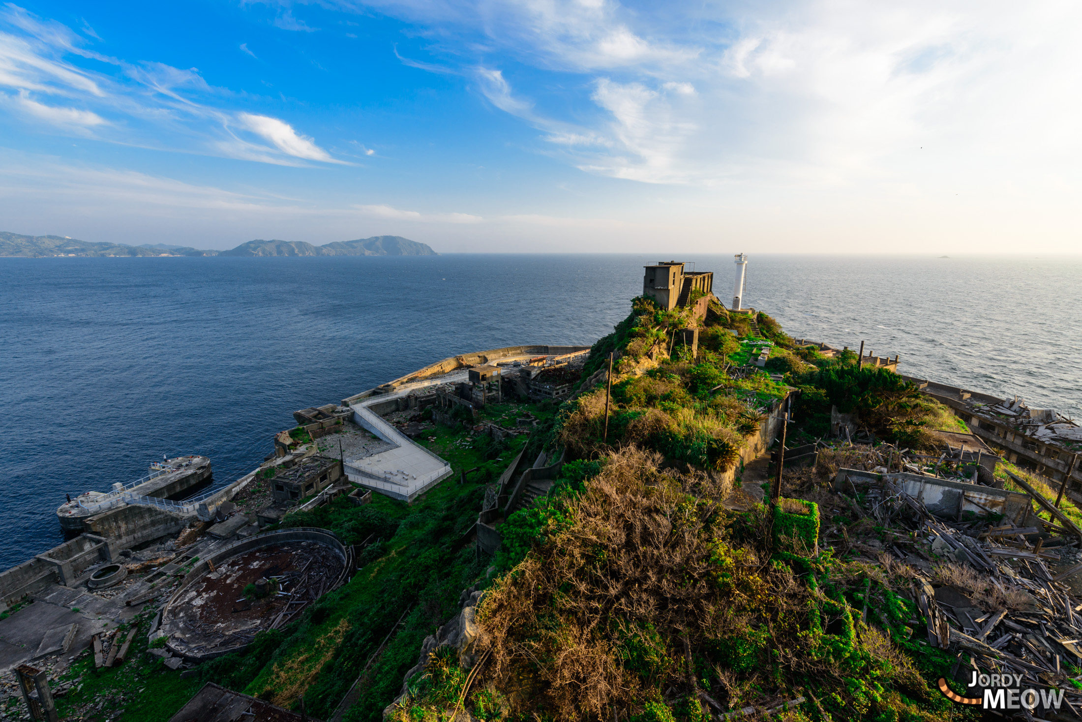 Sunset Over Abandoned Gunkanjima - Eerie landscape of Gunkanjima at sunset, with crumbling buildings.