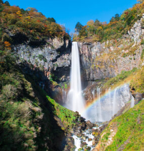 Enchanting autumn waterfall with rainbow and vibrant foliage, creating a mesmerizing display of beauty.