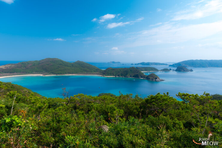 Tranquil view of Okinawas lush bay with turquoise waters and rugged islands.