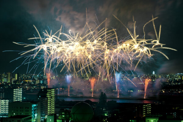 Vibrant fireworks brighten city skyline at night, creating a dazzling and colorful display.