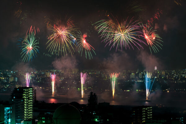 Breathtaking fireworks show illuminating city skyline with vibrant bursts of colors at night.