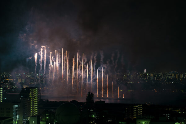 Vibrant fireworks illuminate city skyline in dazzling display of color and light.