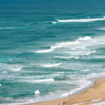 Breathtaking Tottori Sand Dunes in Japan: golden sands, turquoise waters, and serene beauty.