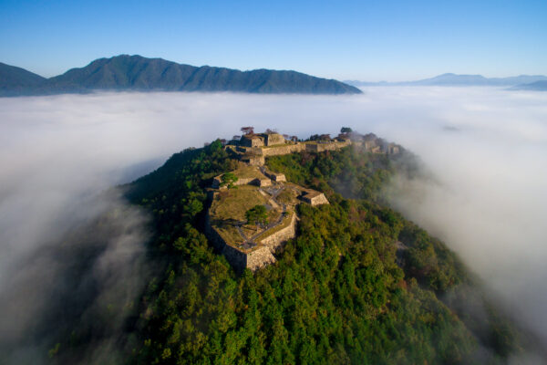 Majestic Takeda Castle on misty hilltop, commanding presence and rich historical legacy.