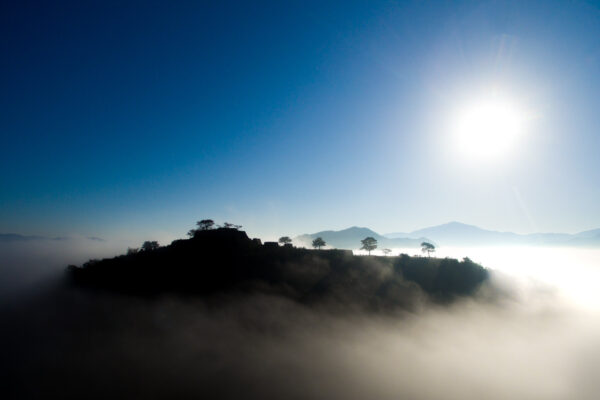 Majestic Takeda Castle at sunset, evoking power and grandeur in a breathtaking scene.