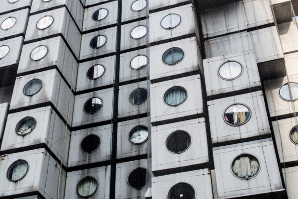 Innovative Metabolist Tower in Tokyo with modular capsules and circular windows by Kisho Kurokawa.