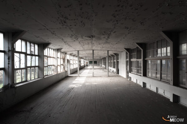 Abandoned Japanese school in Chugoku region with plain white classrooms and weathered wooden floors.