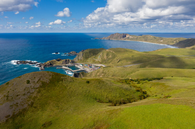 Tranquil and remote beauty of Rebun Island in Japan, with green hills and blue waters.