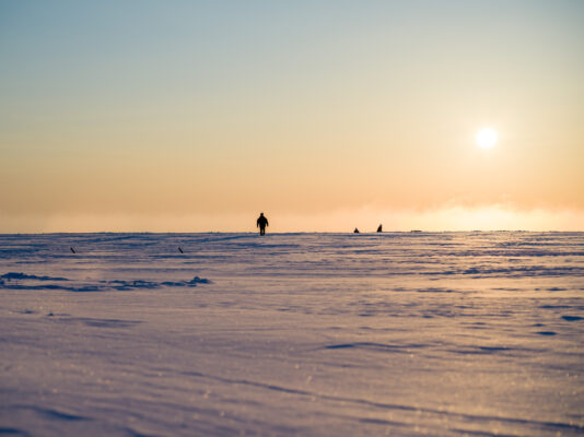 Serene Otsu sunset, frozen river ice floes, silhouetted figure.