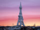 Imposing war memorial tower against sunset skyline.