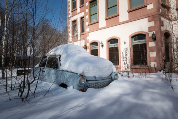 Vintage snow-covered car at abandoned Gluck Kingdom theme park