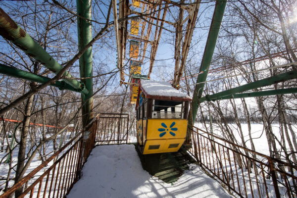 Enchanted winter trolley wonderland in snow-covered theme park.