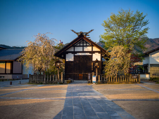 Preserved historic Japanese town, cherry blossoms surround.