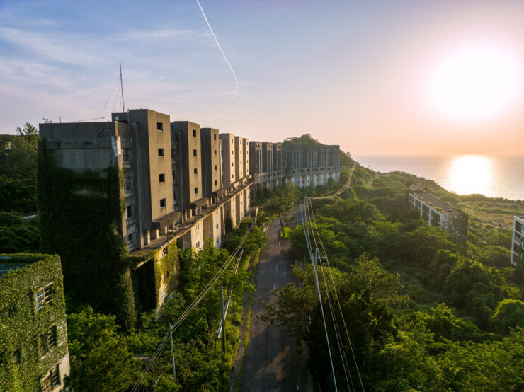 Abandoned structures amidst lush nature on Ikeshima Island.