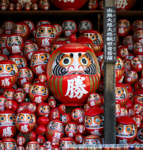 Iconic red Daruma dolls, symbols of perseverance.