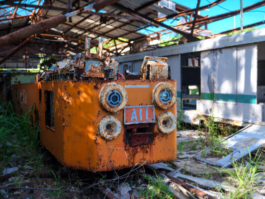 Abandoned rusty machinery overgrown by natures reclamation.