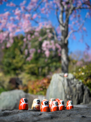 Vibrant orange Kewpie figurines on natural stone backdrop.