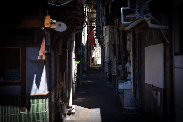 Onomichis historic dimly-lit alleyway, cluttered charm