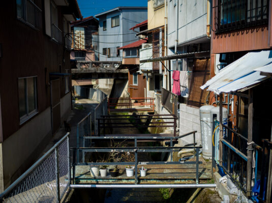 Vibrant Asian canal neighborhood with densely packed architecture.