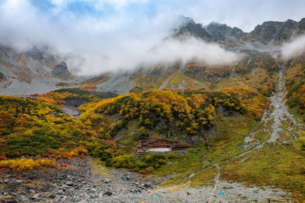 Misty autumn mountain vista with cabin