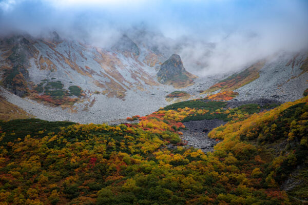 Vibrant autumn mountain scenery, misty peaks.