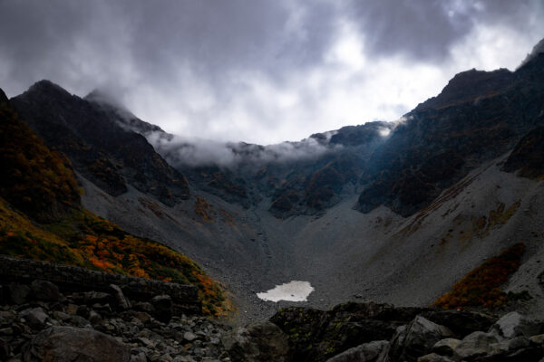 Atmospheric misty mountain peaks, serene lake landscape.