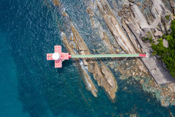 Aerial view of Ashizuri Aquariums red diving platform over cliffs.