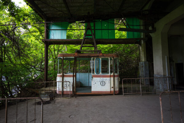 Decaying abandoned forest chairlift overgrown by nature.