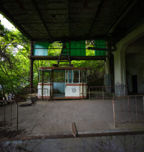 Dilapidated ropeway station overtaken by flourishing forest.