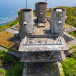Aerial view of abandoned New Muroto Sky Resort concrete towers above Japan’s coastline