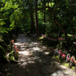 Stone path lined with red-bibbed Jizo statues at Kongōrin-ji Temple in Japan