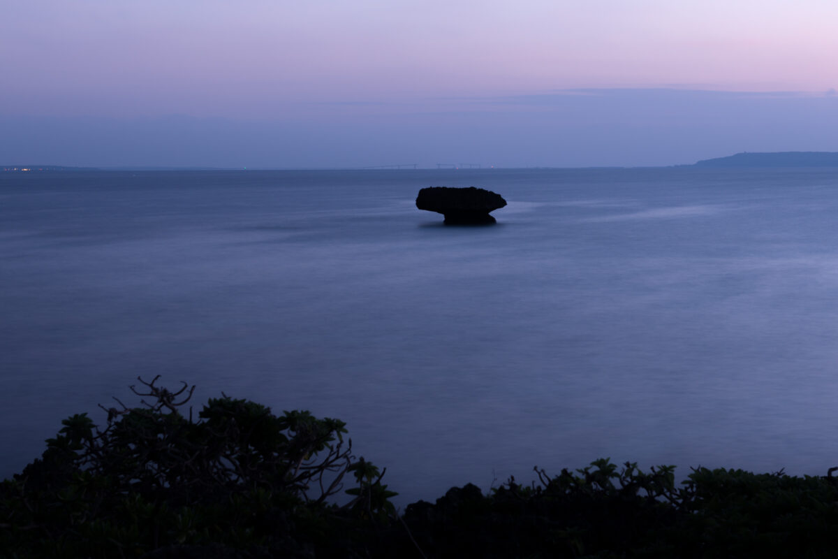 Twilight seascape off Miyako Island, Japan with lone rock and pastel sky