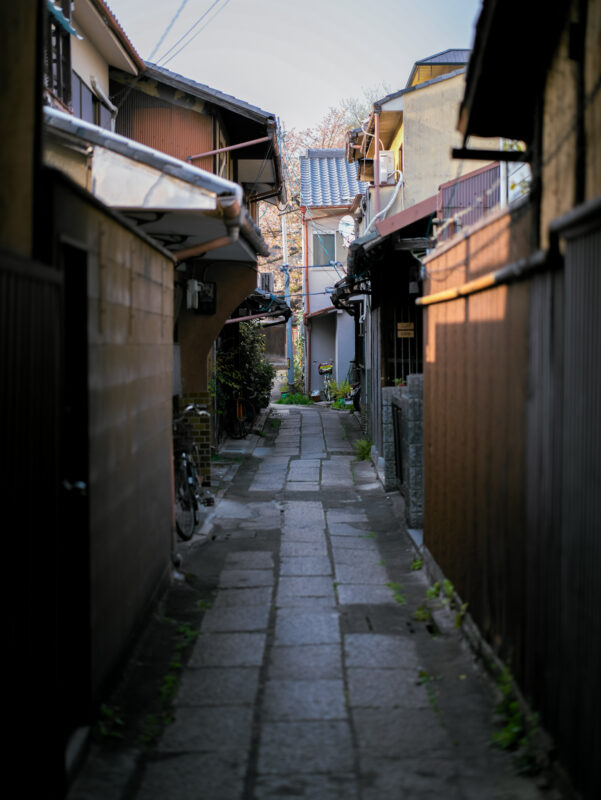 Quiet stone alley in Kyoto’s Gion district lined with traditional wooden machiya houses