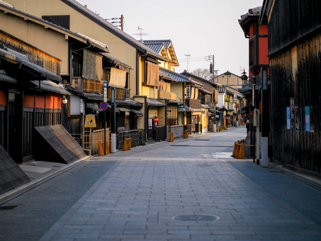 Empty stone-paved street in Kyoto Gion lined with traditional wooden machiya townhouses