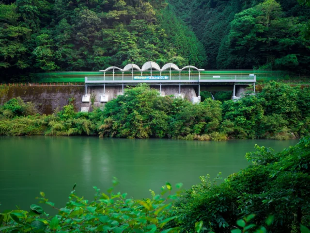 Emerald river, Concrete whispers through green trees— Harmony awakes.エメラルド川、 緑木々を抜ける音— 調和が目を覚ます。#hydropower #natureandtech #emeraldgreen #sustainableenergy #offbeatjapan #hiddenjapan #japan