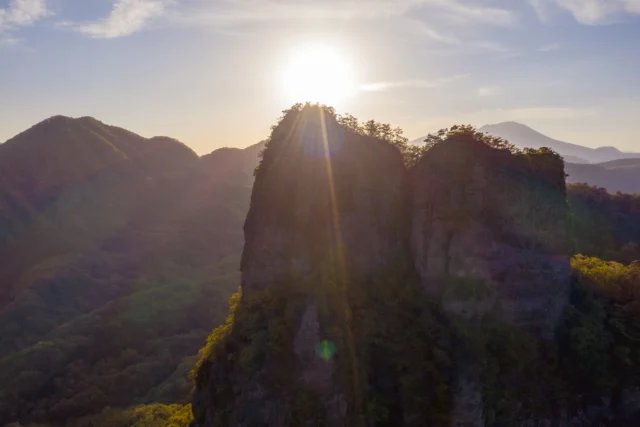 Golden sun descends, Cliffs cradle emerald dreams— Nature's fierce embrace. ---黄金の陽、 崖が翡翠の夢を抱く— 自然の強き抱擁。 ---#offbeatjapan #japan #sunsetviews #natureembrace #mountainbeauty #aeriallandscape #dramaticviews